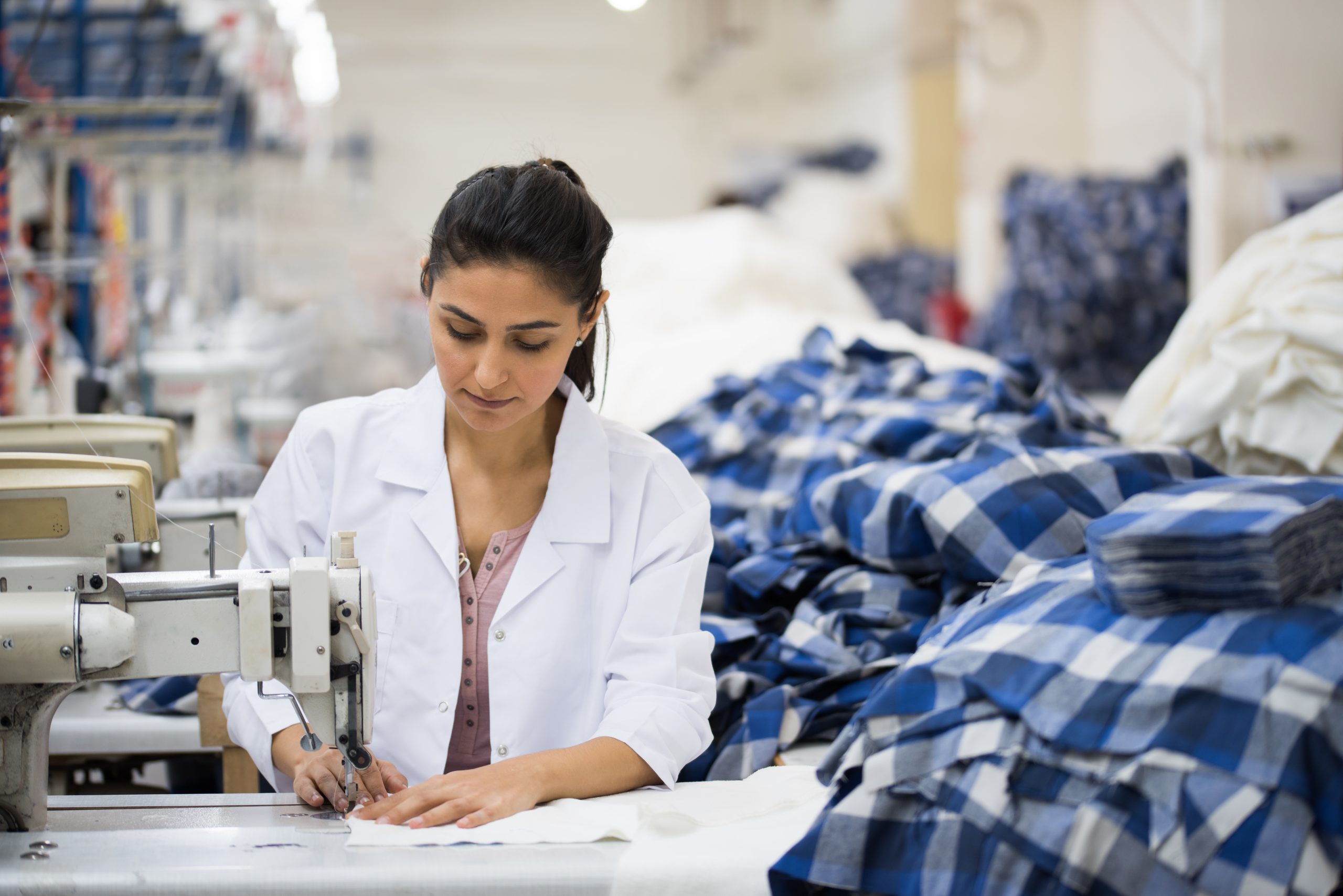 Skilled young tailor sewing on machine